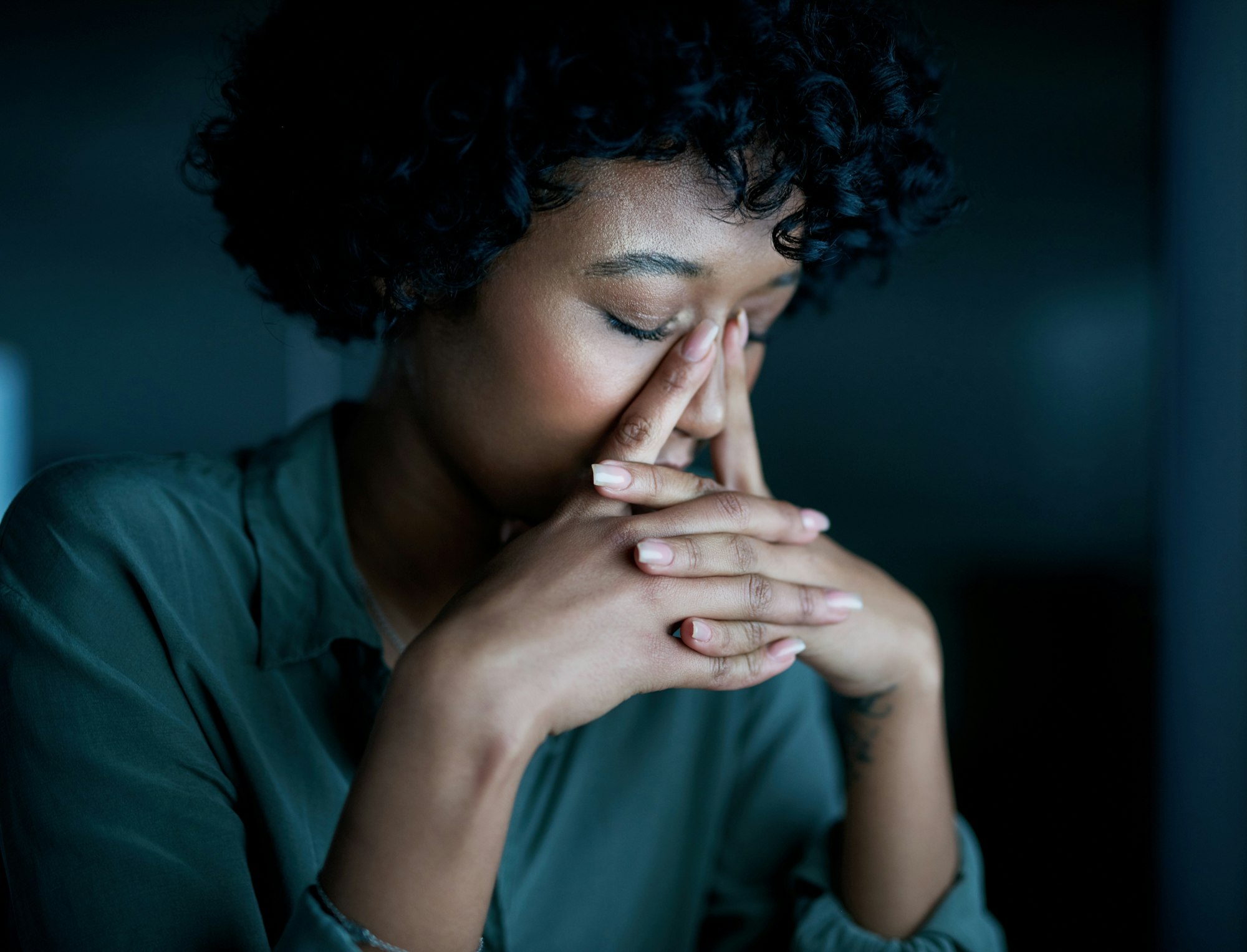 Shot of a young businesswoman looking stressed during a late night at work